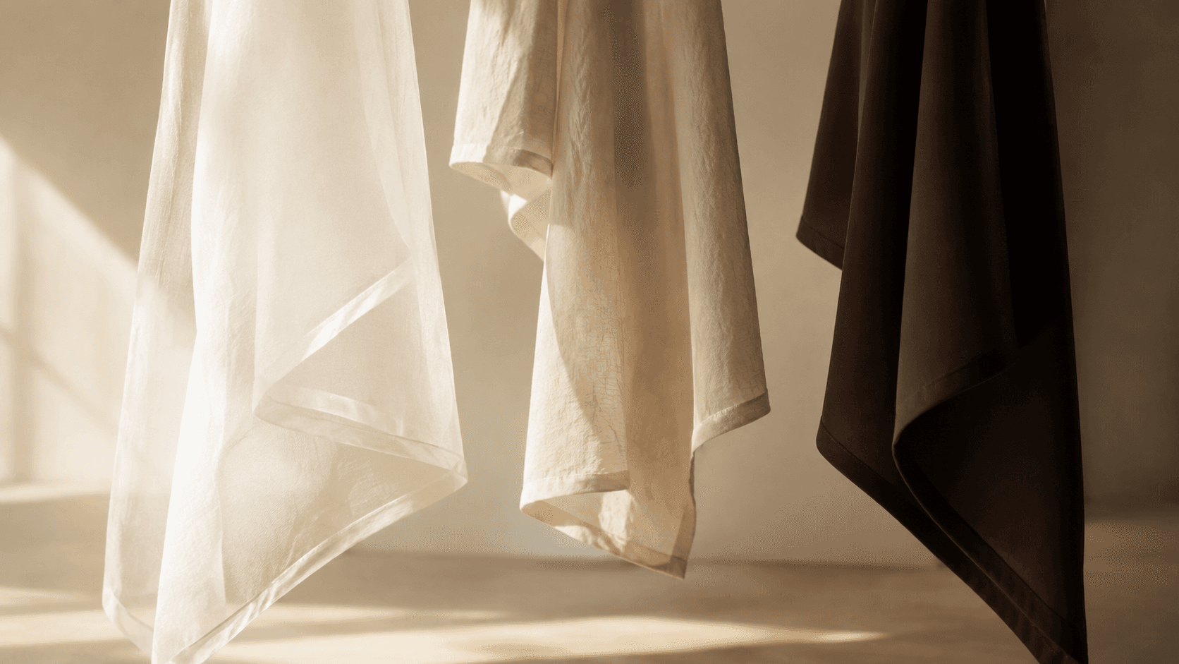 Light and dark fabrics illuminated by sunlight, illustrating how different textiles interact with ultraviolet radiation.