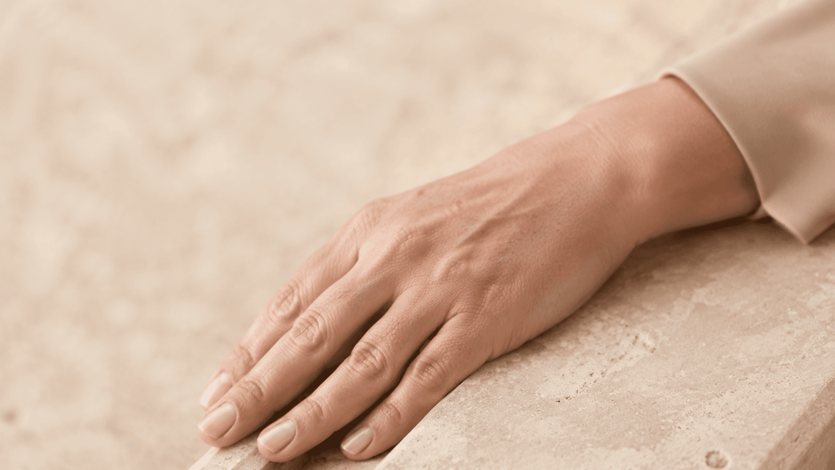 Close-up of a woman’s hand in sunlight, highlighting the delicate skin that is frequently exposed to UV radiation.